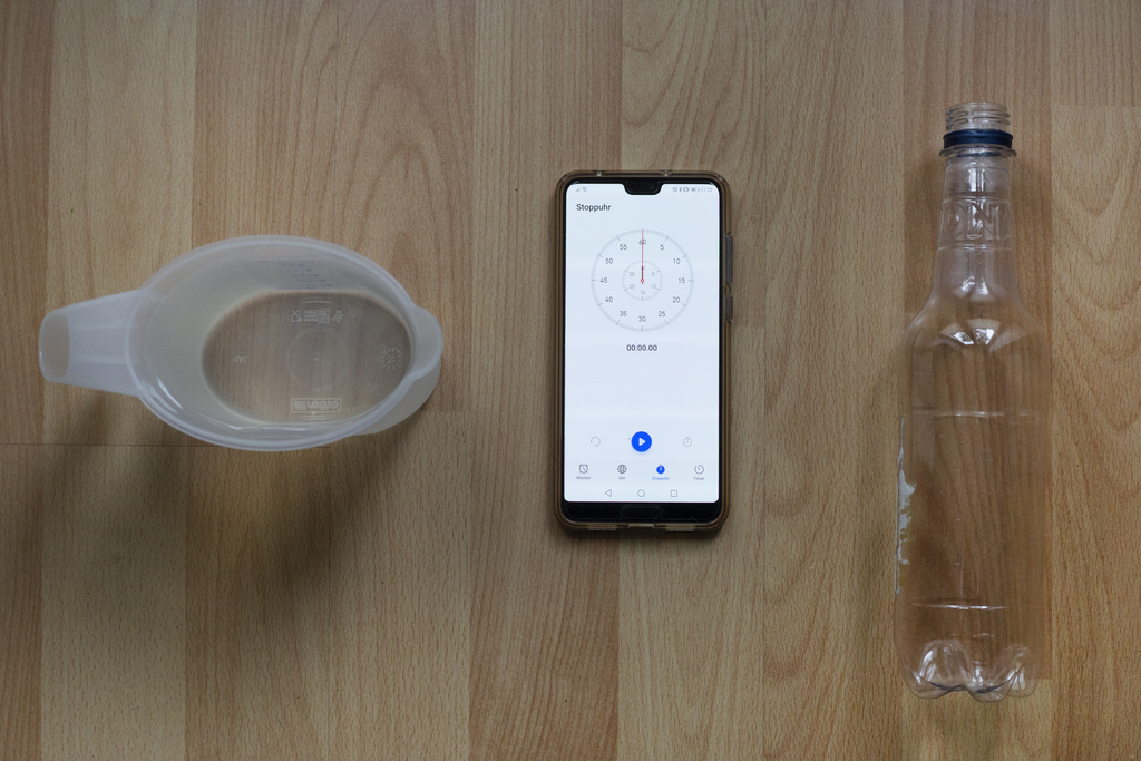 Das Bild zeigt alle Materialien, die man für den Bau eines Flaschentornados benötigt. Der Flaschentornado kann im Unterricht oder zu Hause als Hausaufgabenexperiment gebaut werden.