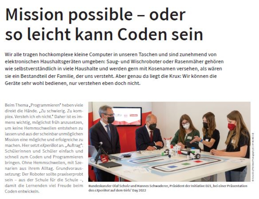 Das Bild zeigt einen Artikel im transparent-Magazin von Cornelsen über den Lernroboter eXperiBot. Kinder und Erwachsene arbeiten an einem Tisch zusammen, um Programmierung spielerisch zu erlernen. Bundeskanzler Olaf Scholz und Hannes Schwadeiter stehen da