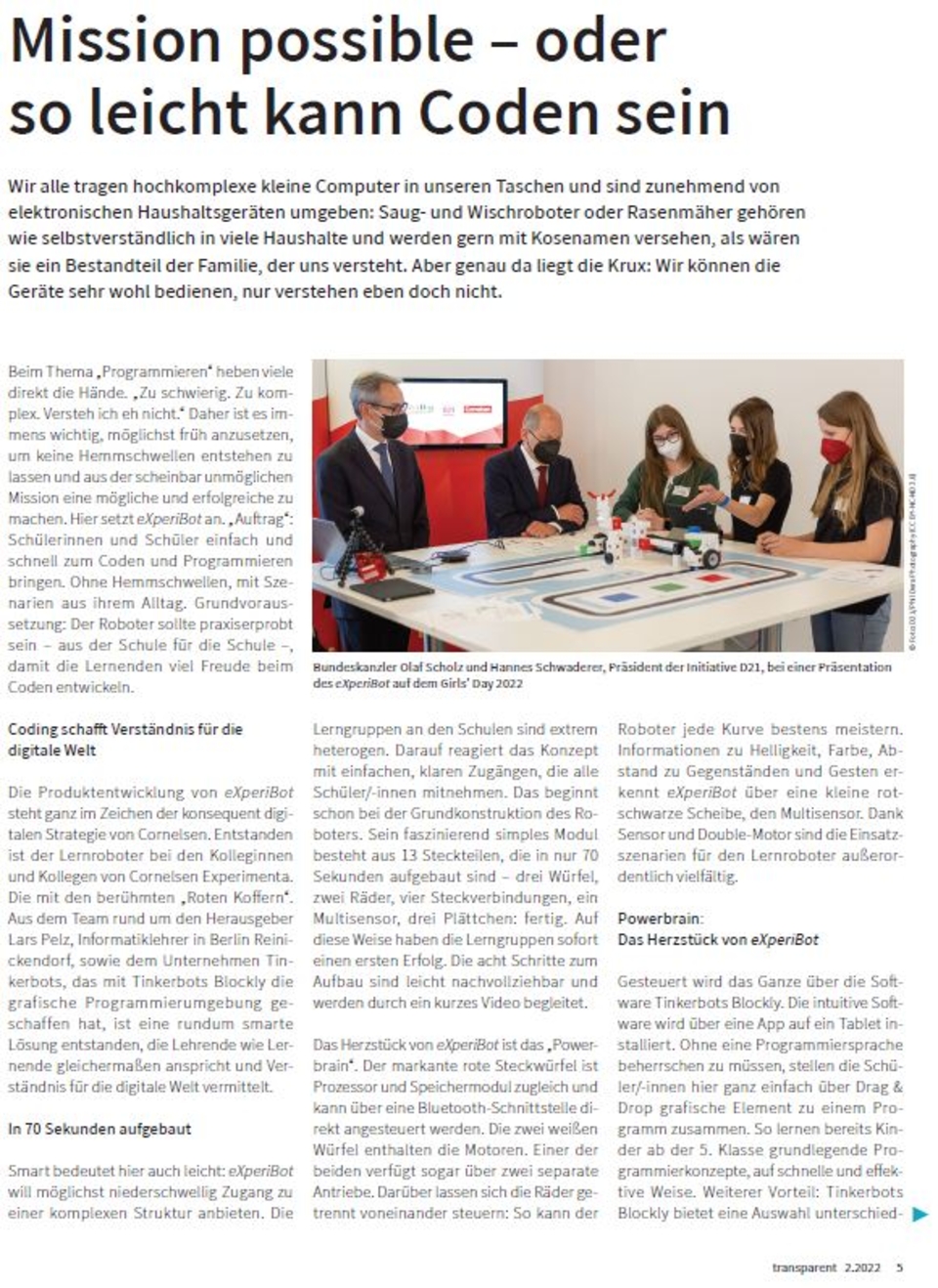 Das Bild zeigt eine Pr&auml;sentation des Lernroboters eXperiBot, der Sch&uuml;lern helfen soll, Coding und Programmierung zu lernen. Auf dem Tisch sind verschiedene Materialien und Roboter-Teile zu sehen, w&auml;hrend Teilnehmer diskutieren und demonstrieren.