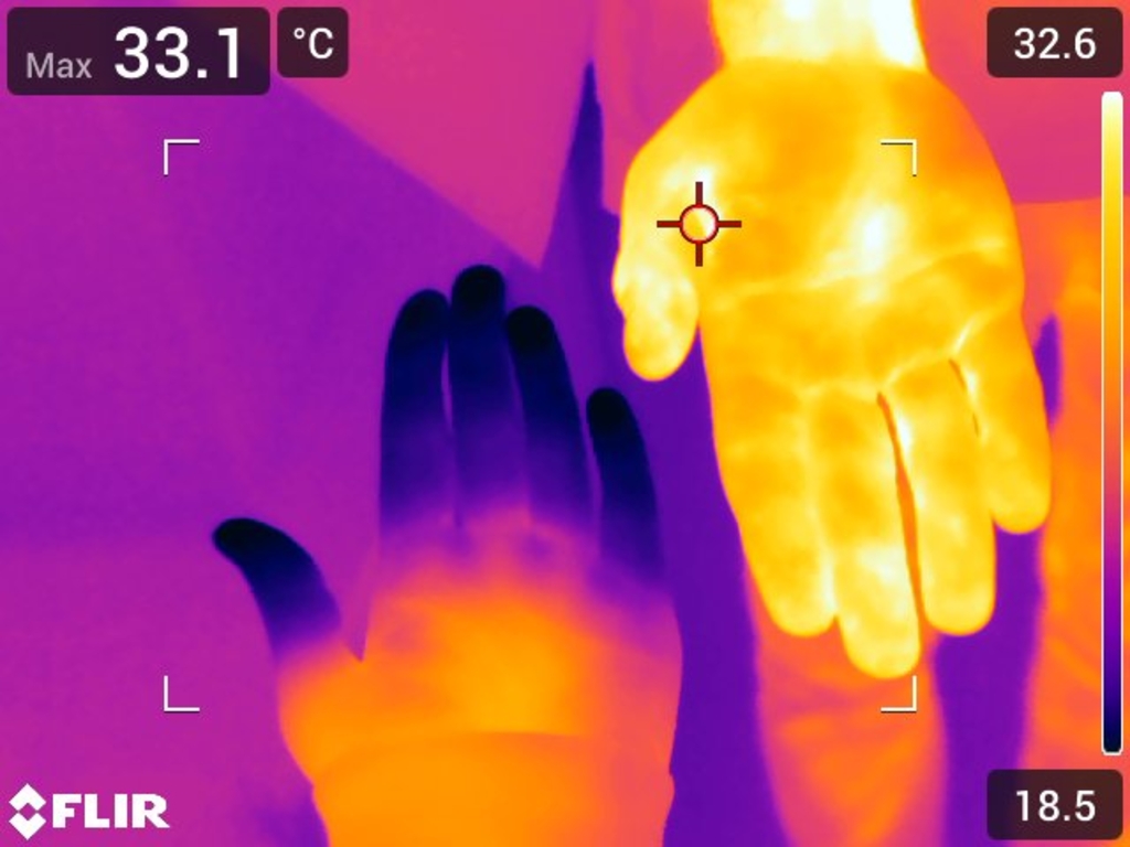 Das Bild zeigt zwei H&auml;nde in einer W&auml;rmebildaufnahme, wobei die Hand oben eine h&ouml;here Temperatur aufweist als die darunter. Die Temperaturanzeigen deutet auf unterschiedliche W&auml;rmeverteilungen hin, die f&uuml;r Experimente im Bildungswesen genutzt werden k&ouml;nne
