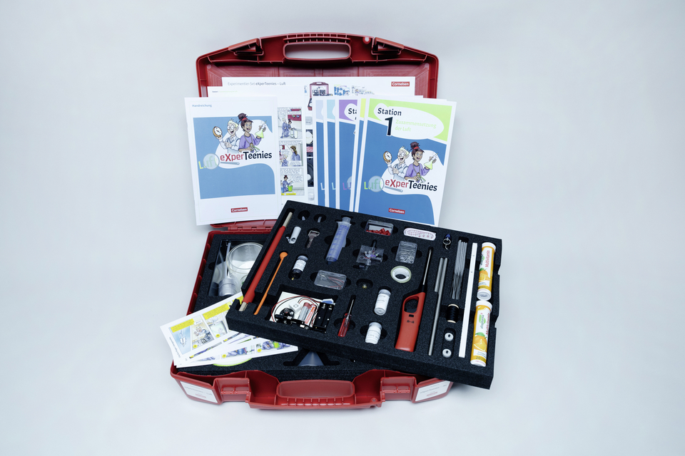 Einblick in den Experimentierkoffer "eXperTeenies", der offene Experimentierkoffer lehnt an der Wand - alle  Materialien sind in einem Schaumstoff an ihrem festen Platz, im Kofferdeckel stehen die Handreichungen sowie die 5 Stationshefte. 