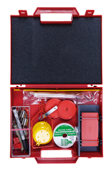 Das Bild zeigt eine rote Werkzeugkiste, die verschiedene Materialien für Experimente enthält. Darunter sind Gegenstände wie Schnüre, Messinstrumente, und kleine Komponenten, die für praktische Bildungsprojekte im Bereich der Naturwissenschaften genutzt we