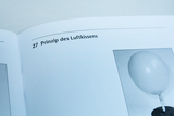Das Bild zeigt eine Seite aus einem Lehrbuch, die das Prinzip des Luftkissens beschreibt. Darunter ist eine Abbildung eines Ballons zu sehen, der zur Veranschaulichung des Themas verwendet wird.