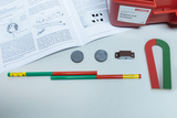Das Bild zeigt Materialien für experimentelle Arbeiten im Bildungswesen, darunter ein U-Magnet, zwei runde Magnete, eine Eisenkern und verschiedene farbige Stäbe. Dazu liegt ein Handbuch, das Anleitungen zu Experimenten mit Magnetismus bietet.