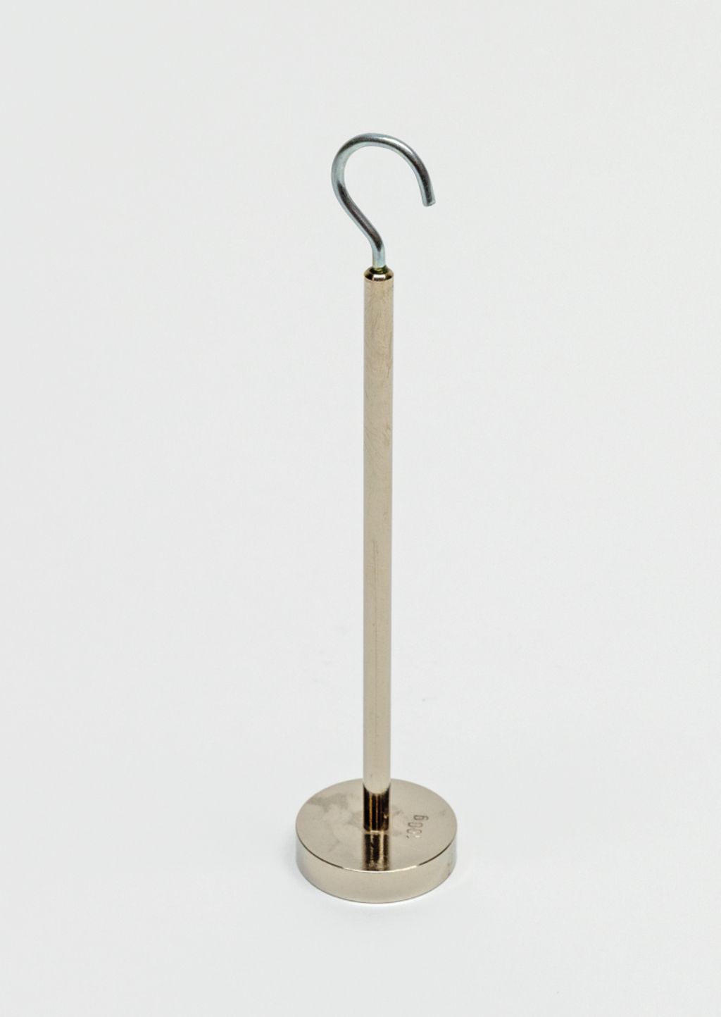 Das Bild zeigt einen stabilen Standfuß mit einem vertikalen Stab, der an der Spitze einen gebogenen Haken hat. Dieses Gerät wird häufig im Experimentier- und Bildungsbereich eingesetzt, um verschiedene Materialien oder Objekte zu halten oder zu befestigen