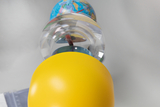 Das Bild zeigt eine gelbe Kugel, die den Unterteil eines Modells bildet, über dem ein Globus schwebt. Das Modell könnte zur Veranschaulichung von physikalischen oder geographischen Konzepten im Bildungsbereich dienen.