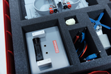 Das Bild zeigt einen aufgeräumten Experimentierkasten, der verschiedene Komponenten wie Batteriefächer, Kabel und einen kleinen Motor enthält. Die Teile sind in einer schützenden Schaumstoffeinlage organisiert, um optimale Lagerung und Transport zu gewähr