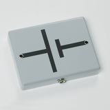 Das Bild zeigt ein graues Gehäuse mit einer schwarzen Schaltung, die anscheinend eine elektrische Schaltung darstellt. An der Unterseite befinden sich zwei Anschlüsse, die für Experimentierzwecke in der Elektrotechnik verwendet werden können.