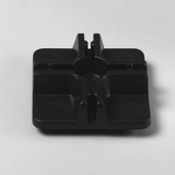 Das Bild zeigt ein quadratisches, schwarzes Kunststoffteil mit abgerundeten Ecken und vertieften Bereichen. Es scheint sich um eine Halterung oder Basis zu handeln, die möglicherweise für experimentelle Setups im Bildungsbereich verwendet wird.