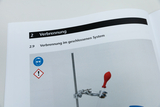 Das Bild zeigt eine Seite aus einem Lehrbuch oder einer Anleitung, die sich mit dem Thema "Verbrennung" beschäftigt, insbesondere mit "Verbrennung im geschlossenen System". Zusätzlich sind Sicherheitswarnungen in Form von Symbolen abgebildet.
