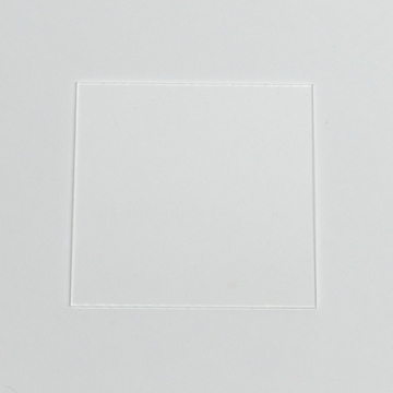 Das Bild zeigt eine klare, rechteckige Folie, die in einen weißen Hintergrund eingelassen ist. Diese Folie könnte Teil eines Setups für Experimente im Bildungsbereich sein, um verschiedene Materialien oder Reaktionen zu beobachten.