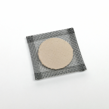 Das Bild zeigt eine quadratische Drahtgitterplatte, die eine runde Pappe in der Mitte hält. Diese Materialien könnten für verschiedene Experimente im Bildungsbereich verwendet werden, etwa in der Chemie oder Physik.