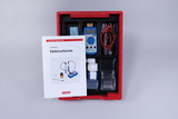 Das Bild zeigt einen Geräte-Set zur Durchführung elektrochemischer Experimente, bestehend aus einem Messgerät, Kabeln und diversen Reagenzien. Zudem liegt ein Handbuch mit Anleitungen zum Experimentieren bei.