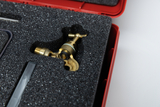 Das Bild zeigt ein hochwertiges Armaturen-Teil aus Messing, das in einem gepolsterten Koffer liegt. Der Koffer ist rot und der Innenraum ist mit Schaumstoff ausgekleidet, um das Bauteil sicher zu verwahren.