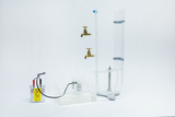 Das Bild zeigt ein Experimentiergerät, das aus einem kleinen Behälter mit einer Pumpe, zwei Wasserhähnen und transparenten Röhren besteht. Es ist für den Einsatz im Bildungsbereich konzipiert und dient zur Durchführung von physikalischen Experimenten.