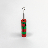 Das Bild zeigt ein zylindrisches Experimentiergerät, das in rot und grün lackiert ist und einen metallischen Haken an der Spitze aufweist. Es scheint für physikalische Experimente im Bildungsbereich konzipiert zu sein.