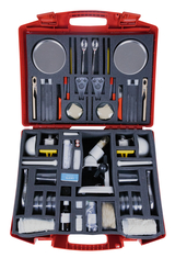 Das Bild zeigt eine rote Werkzeugkiste, die mit verschiedenen Experimentiermaterialien und -geräten ausgestattet ist. Sie enthält unter anderem Gläser, Mikroskopzubehör, Pipetten und andere Schulsachen für naturwissenschaftliche Experimente.