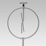 Das Bild zeigt ein Experimentiergerät, das aus einem runden Rahmen mit einer senkrechten Halterung und einem beweglichen, gebogenen Element besteht. Es wird vermutlich verwendet, um physikalische Prinzipien oder Bewegungen zu demonstrieren.