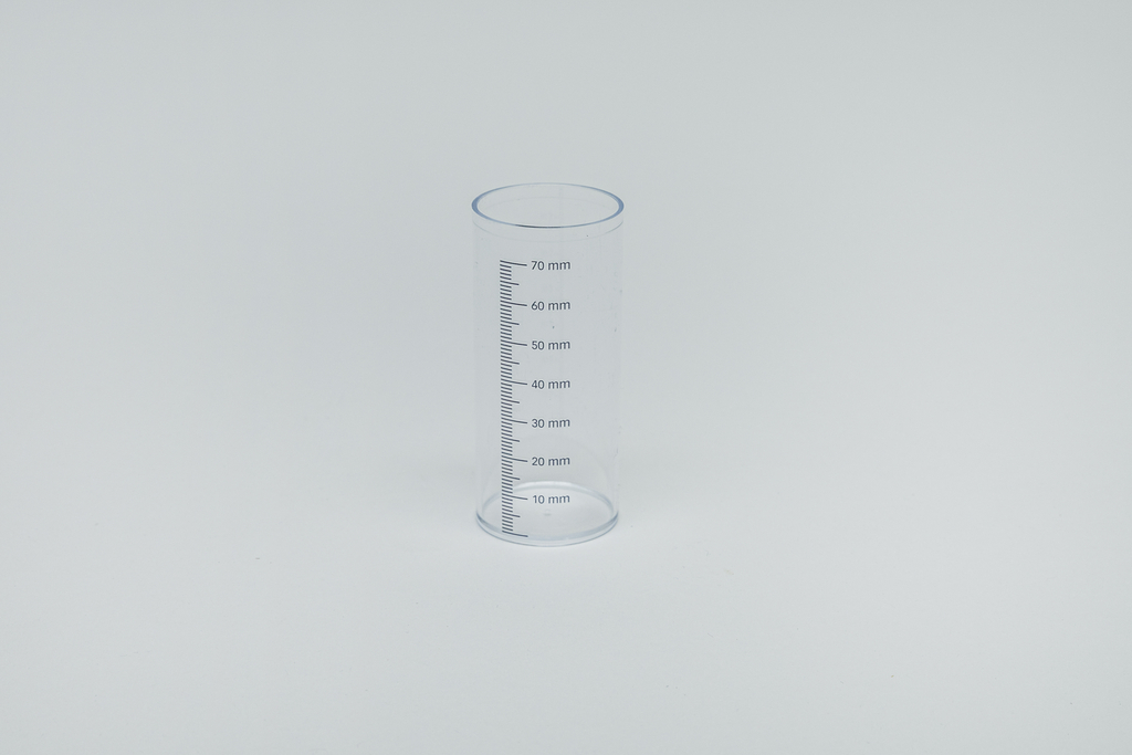 Das Bild zeigt einen transparenten Messzylinder aus Kunststoff mit einer Höhe von 70 mm. An der Außenseite sind präzise Messmarkierungen angebracht, die eine genaue Volumenmessung von Flüssigkeiten ermöglichen.