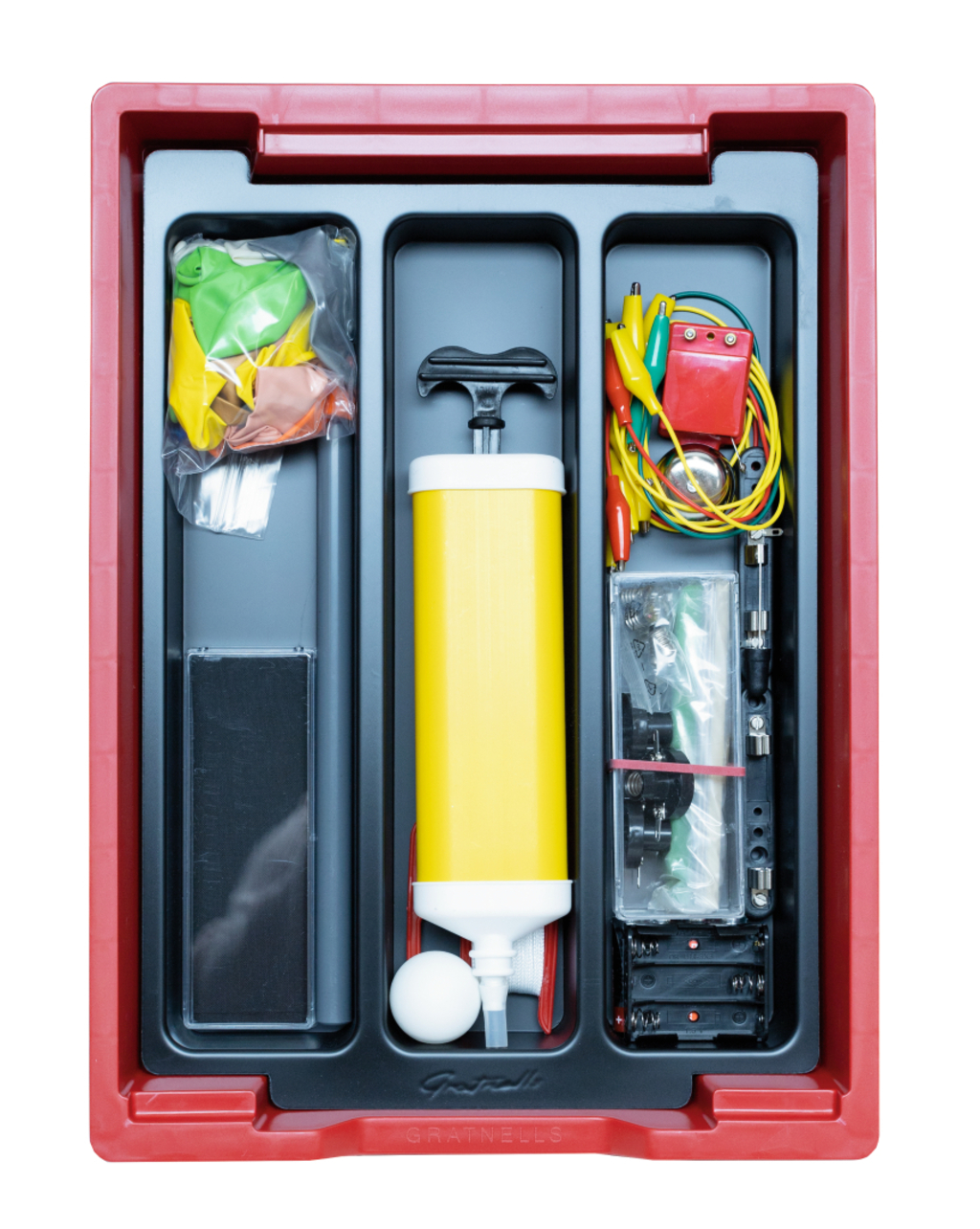 Das Bild zeigt ein Experimentierkit, das in einem roten Behälter angeordnet ist. Es enthält unter anderem Luftballons, eine Luftpumpe, verschiedene Drähte und ein elektrisches Spielzeug, ideal für Schulprojekte im naturwissenschaftlichen Unterricht.