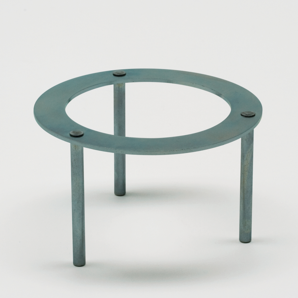 Das Bild zeigt einen stabilen Metallständer mit drei Beinen und einer runden, offenen Fläche in der Mitte. Er dient wahrscheinlich zur Unterstützung von Glaswaren oder anderen Experimentierutensilien in einem Labor oder Klassenzimmer.