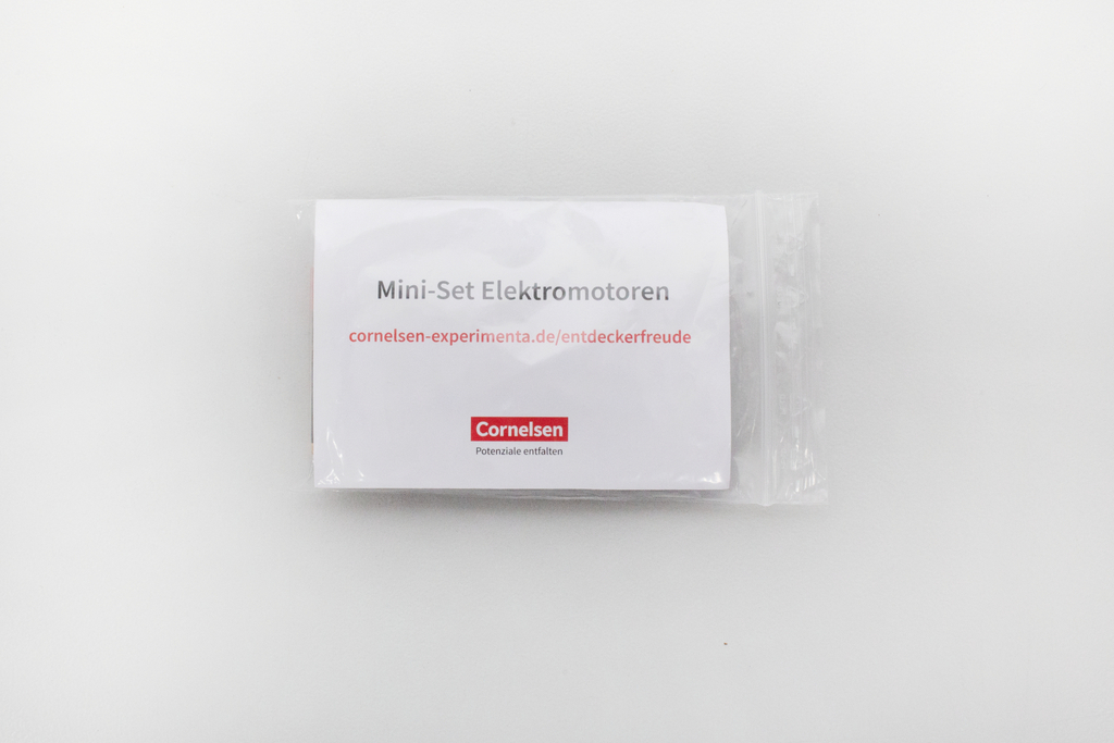 Das Bild zeigt eine Verpackung mit dem Titel "Mini-Set Elektromotoren". Die Verpackung ist in einer transparenten Folie, mit der Aufschrift des Anbieters Cornelsen sowie einer URL für weitere Informationen.