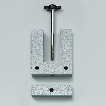 Das Bild zeigt eine graue Halterung aus Metall, die aus zwei Teilen besteht: einer U-förmigen Basis mit einer Gewindestange in der Mitte und einer flachen Platte. Diese Vorrichtung wird vermutlich für Experimentierzwecke im Bildungsbereich verwendet, um Objekte zu fixieren.