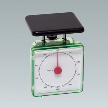 Das Bild zeigt eine analoge Federwaage mit einem transparenten Gehäuse, die für Messungen in Experimenten verwendet wird. Die Skala reicht bis 500 Gramm, mit Markierungen in 5-Gramm-Schritten.