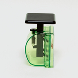 Das Bild zeigt ein Experimentiergerät in grüner Kunststoffausführung mit einem schwarzen Hebel. Es scheint für Bildungszwecke im naturwissenschaftlichen Unterricht entwickelt worden zu sein, um verschiedene physikalische Phänomene zu demonstrieren.