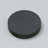 Das Bild zeigt einen runden, flachen magnetischen Gegenstand aus dunklem Material. Er könnte für Experimentierzwecke in der Schule, wie beispielsweise für magnetische Felder oder physikalische Demonstrationen, verwendet werden.