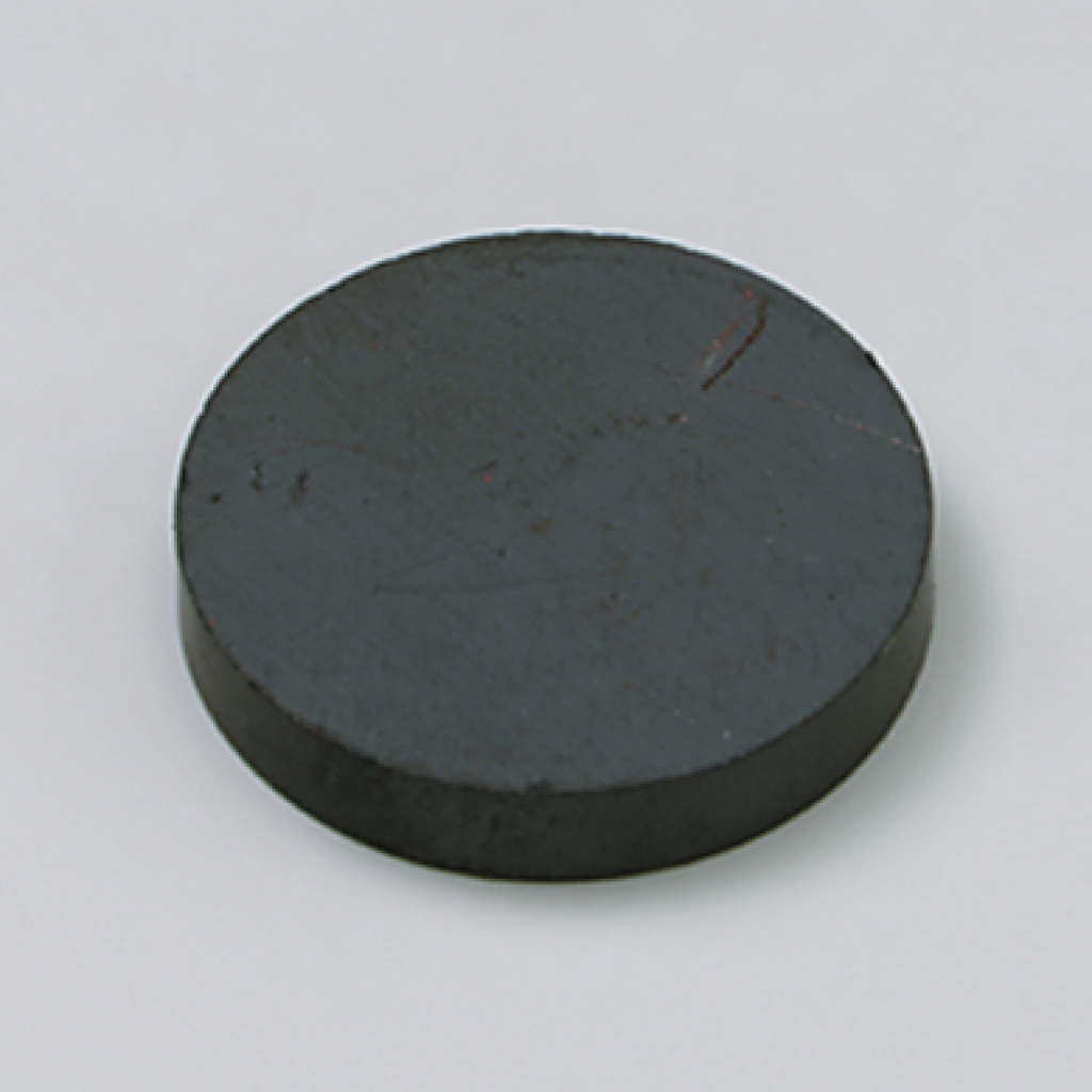 Das Bild zeigt einen runden, flachen magnetischen Gegenstand aus dunklem Material. Er könnte für Experimentierzwecke in der Schule, wie beispielsweise für magnetische Felder oder physikalische Demonstrationen, verwendet werden.