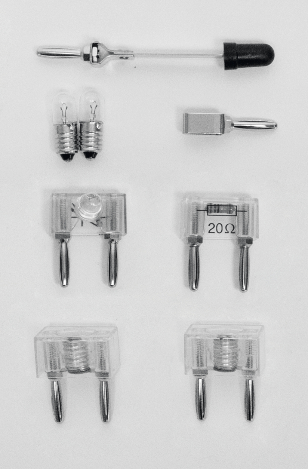 Das Bild zeigt verschiedene Experimentierbauteile, darunter Glühlampen, Widerstände und Stecker. Diese Teile sind für den Einsatz in Bildungsprojekten im deutschen Schulwesen konzipiert und unterstützen praktische Experimente im Bereich Elektrizität.