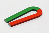 Das Bild zeigt einen U-förmigen Magneten, der in zwei Farben unterteilt ist: die eine Hälfte ist grün und die andere rot. Der Magnet hat eine glatte Oberfläche und könnte für Experimente in der Schule verwendet werden, um magnetische Felder zu demonstrieren.