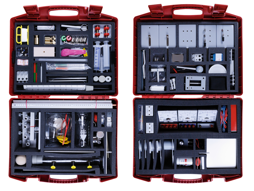 Das Bild zeigt eine rote Werkzeugkiste, die mit verschiedenen Experimentiermaterialien für das Bildungswesen gefüllt ist. In den Fächern sind unter anderem Messgeräte, Zubehörteile, Pipetten und mechanische Komponenten angeordnet, die für wissenschaftliche Experimente genutzt werden können.