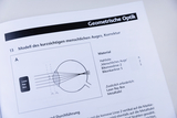 Das Bild zeigt eine Darstellung eines Modells des kurzsichtigen menschlichen Auges, inklusive Korrekturmaßnahmen. Es listet die benötigten Materialien für das Experiment sowie die dazugehörigen Anweisungen auf.