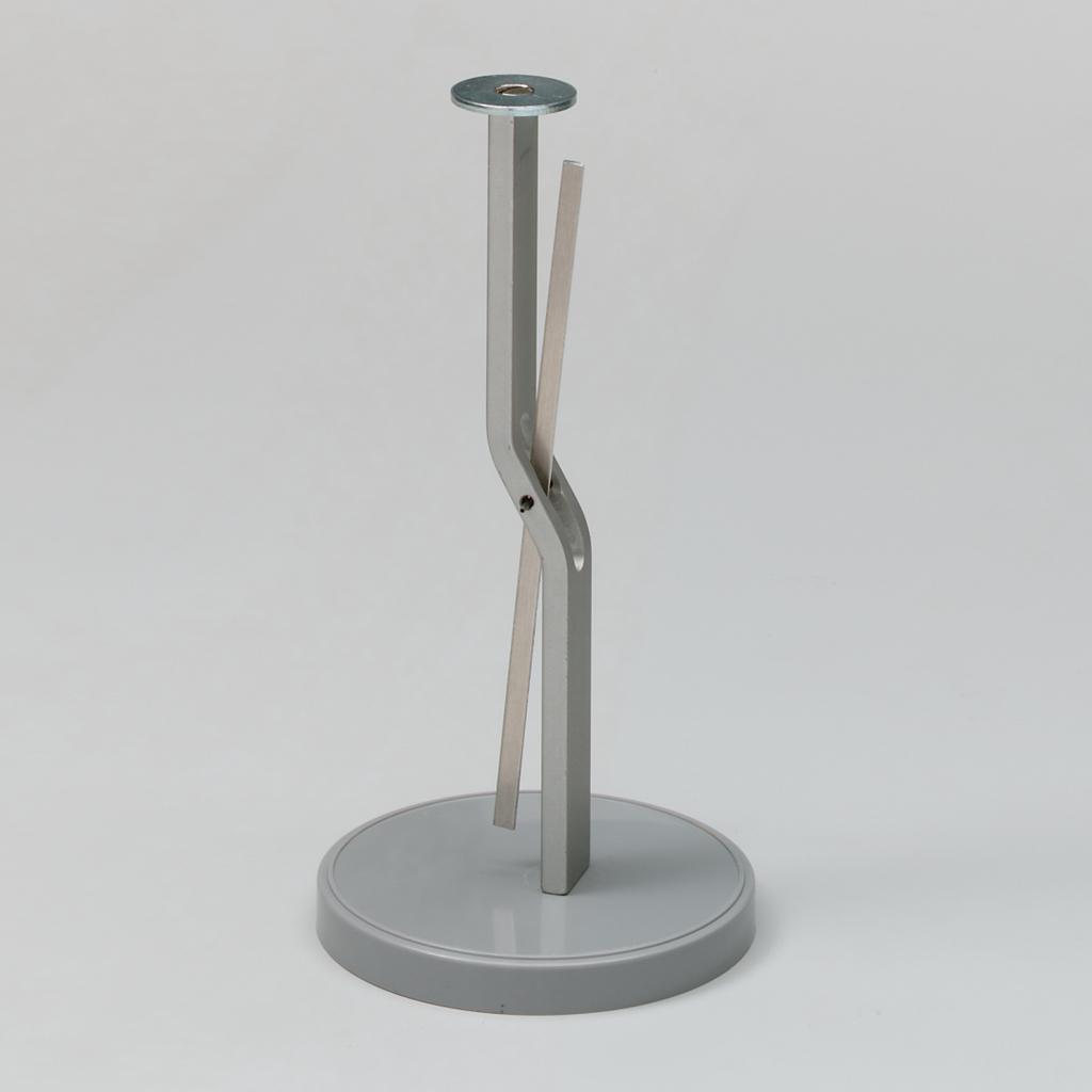 Das Bild zeigt einen stabilen Ständer aus Metall mit einem runden Sockel und zwei gebogenen Halterungen, die miteinander verbunden sind. Dieses Experimentiergerät könnte für physikalische Demonstrationen oder Tests verwendet werden.