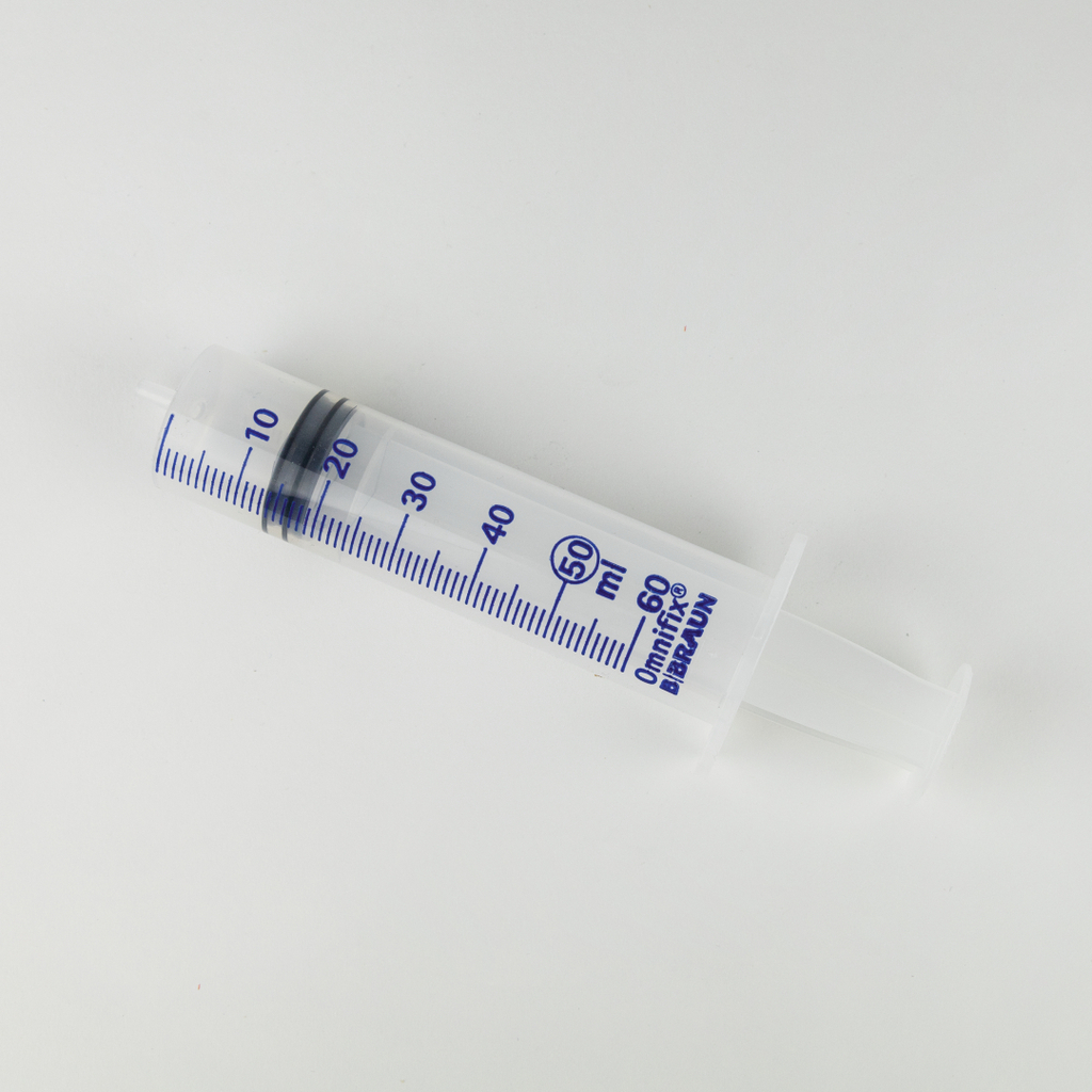 Das Bild zeigt eine transparente Spritze mit einer Kapazität von 60 ml, die mit blauen Markierungen zur genauen Abmessung versehen ist. Sie ist ein nützliches Werkzeug für Experimente im Bildungsbereich, insbesondere in den Naturwissenschaften.