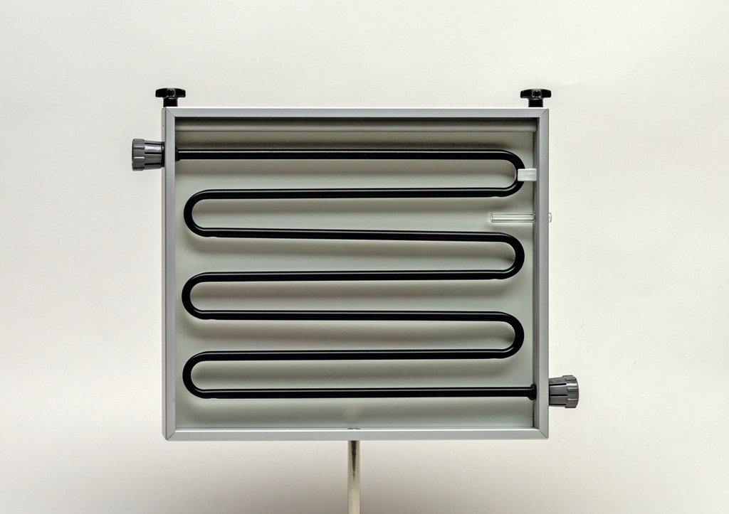 Das Bild zeigt ein Heizgerät mit mehreren gewundenen Rohren in einem silbernen Gehäuse. Dieses Gerät dient wahrscheinlich zur Durchführung von Experimenten im Bildungsbereich, insbesondere zur Demonstration von Wärmeübertragung.