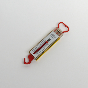 Das Bild zeigt ein einfaches Federwiegehöhenmessgerät mit rot gefärbtem Haltegriff und Haken. Es verfügt über eine Skala zur Messung des Gewichts in Gramm und wird häufig in BildungsExperimenten verwendet.