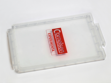 Das Bild zeigt einen klaren, rechteckigen Kunststoffbehälter mit einem roten Logo von Cornelsen und dem Schriftzug "Experimenta". Der Behälter scheint für die Aufbewahrung von Experimentiermaterialien im Bildungsbereich konzipiert zu sein.