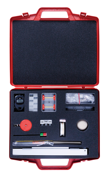 Das Bild zeigt ein rotes Kunststoffgehäuse, das einen Experimentierkasten für den Unterricht enthält. In der Box sind verschiedene Werkzeuge und Materialien angeordnet, darunter ein Stoppuhr, eine Rutschbahn und andere Utensilien für wissenschaftliche Experimente.