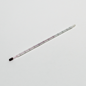 Das Bild zeigt ein Glasthermometer mit einer klaren Skala zur Temperaturmessung, das im Bildungsbereich verwendet wird. Es verfügt über eine markierte Quecksilbersäule, die zwischen den Temperaturgrenzen sichtbar ist.