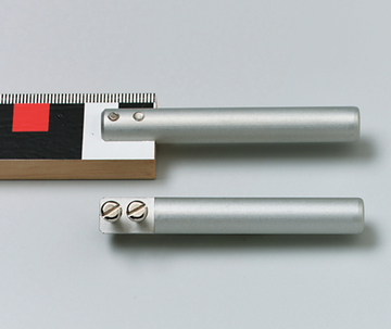 Das Bild zeigt zwei metallische Stäbe, die in einer experimentellen Anordnung verwendet werden können. Daneben befindet sich ein Holzlineal mit einer farblichen Markierung zur besseren Orientierung.