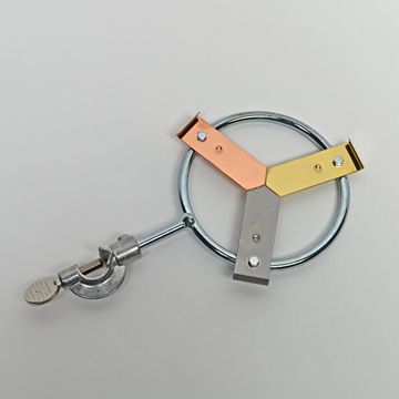Das Bild zeigt eine chemische Halterung aus Metall mit drei farblich unterschiedlichen Halteklammern, die zur Unterstützung von Experimenten verwendet wird. An einem Ende der Halterung befindet sich eine Klemme, um das Gerät sicher zu befestigen.