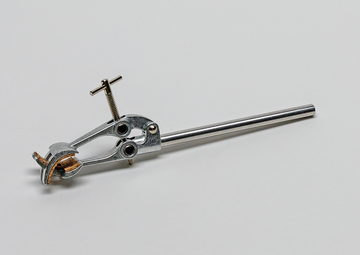 Das Bild zeigt ein verchromtes, metallisches Haltegerät mit einer verstellbaren Klemmvorrichtung, das zur Sicherung von Experimentiermaterialien genutzt wird. Es hat einen langen, runden Stab und eine Greifzange, die stabilen Halt bietet.