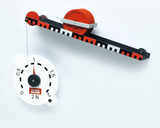 Das Bild zeigt eine experimentelle Einrichtung mit einer Scheibe und einer Federwaage, die zur Demonstration von physikalischen Prinzipien verwendet wird. An einem Ende hängt das Gewicht, während die Skala auf der Waage die Zugkraft anzeigt.