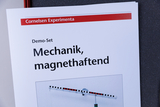 Das Bild zeigt ein Demo-Set mit dem Titel „Mechanik, magnethaftend“ aus dem Sortiment von Cornelsen Experimenta. Es beinhaltet eine Anleitung zur Durchführung von Experimenten im Bereich der Mechanik, die magnetische Eigenschaften demonstrieren.