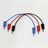 Das Bild zeigt mehrere farbige Verbindungskabel (blau, rot und schwarz) mit jeweils zwei Steckern an den Enden. Diese Kabel sind typischerweise in Experimentierkästen für Bildungszwecke verwendet, um elektrische Schaltungen zu erstellen.