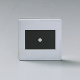 Das Bild zeigt ein rechteckiges Gerät mit einer glänzenden Oberfläche und einem zentralen schwarzen Bereich, in dem sich ein kleiner weißer Punkt befindet. Es scheint für experimentelle Zwecke in der Bildung konzipiert zu sein, möglicherweise für optische Versuche.