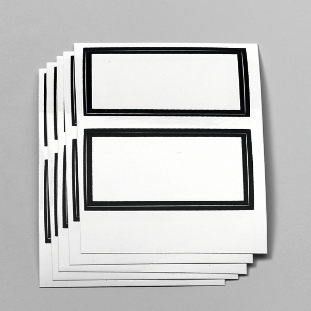 Das Bild zeigt mehrere identische, unbedruckte Papieretiketten mit schwarzen Rahmen. Diese Etiketten eignen sich für Beschriftungen und sind ideal für den Einsatz im schulischen Experimentierbedarf.